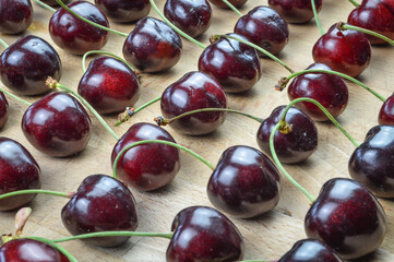 Cherries collection. Ordered red organic ripe cherries on a wooden background close up