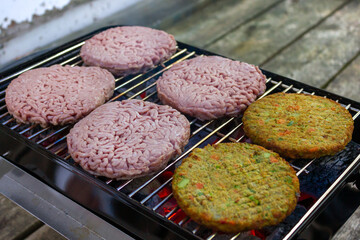 vegetarian and meat cutlets for burgers to be grilled on coal on a small tourist's grill
