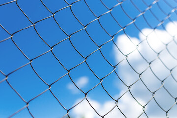 Metal fence close-up. The territory of the fence, against the sky.