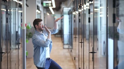 Funny excited happy business man employee winner triumphant dancing in slow motion in office hallway alone having fun celebrate business success reward corporate promotion in victory dance concept