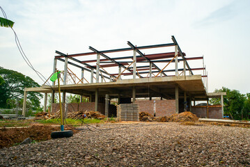 Fototapeta na wymiar Perspective of house structure under construction at site with blue sky background