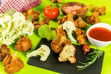 Fried cauliflower closeup on kitchen table. Vegetarian food. Cauliflower with chili sauce. Healthy vegetables.