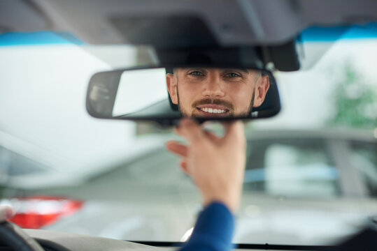 Young Man Looking In Rear View Mirror.