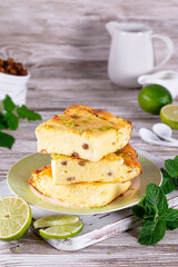 Cottage cheese casserole with raisins, honey and mint, lime slices on a plate on a white table