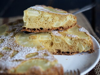 Home cooking.Sponge cake with pineapple on a dark background.