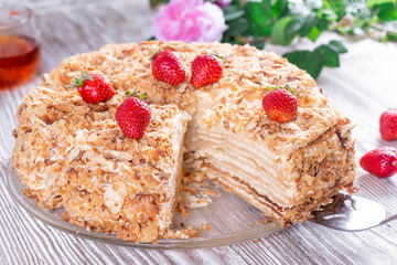 Sliced Napoleon cake on a white wooden table