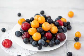 fresh blueberries, physalis and cherry in a beautiful bowl