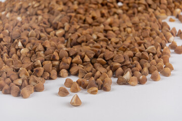 Buckwheat kernels pour out from a glass jar, agronomy world crop