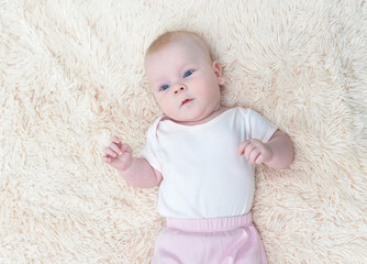 Little baby girl lying on fluffy blanket