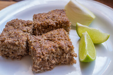 Kibe roast on white dish with lemmon and onion. Brazilian snack