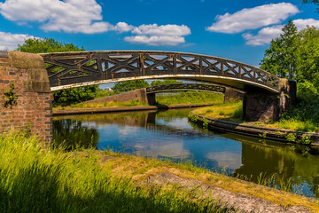 Fototapeta na wymiar A view of a pair of bridges at the junction of the Birmingham and Dudley canals in summertime