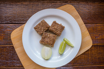 Kibe roast on white dish with lemmon and onion. Brazilian snack