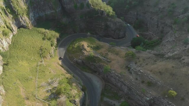 Birds eye view of winding scenic road through green gorge