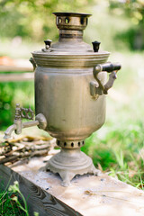 Russian traditional teapoton a background of greenery. Summer picnic weather, fine art style
