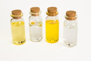 Beautiful photo of small bottles with cork stoppers filled with fantastic fragrant oils, essential oils, rose water and daisies