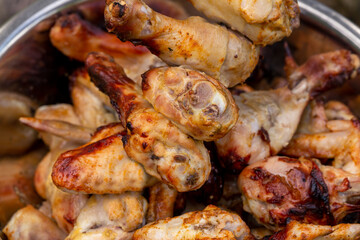 Juicy appetizing grilled chicken legs and wings. Close-up.