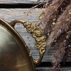vintage swedish brass tray in scandinavian style on a wooden table with dried flowers