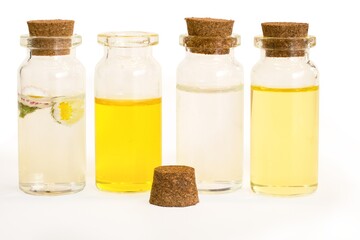 Beautiful photo of small bottles with cork stoppers filled with fantastic fragrant oils, essential oils, rose water and daisies