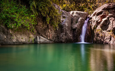 Fototapeta na wymiar Beautiful small waterfall view in green water river