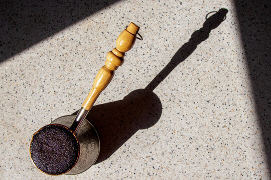 Cezve With Coffee Casts A Shadow On The Marble Countertop. View From Above