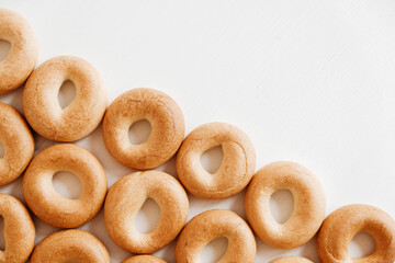 Drying or mini round bagels on a white wooden background. Top view. Copy, empty space for text