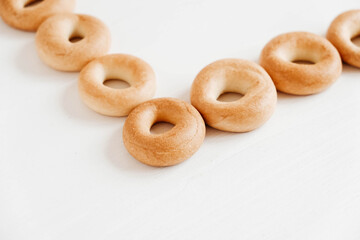 Drying or mini round bagels on a white wooden background. Copy, empty space for text