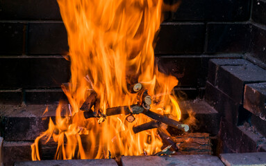 A bricked, barbecue stove with barbecue with flaming fire from charred