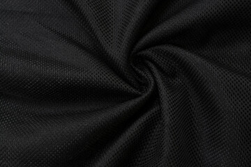 Smooth elegant black background, selective focus, texture. Shiny draped wrinkled luxurious cloth. Soft black plush fabric drapery