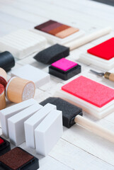 handicraft equipments, ink pads, lino cutter, paint roller and plasticine blocks on white wood table