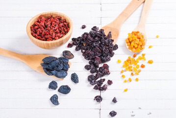 dried goji, cherry, raisin and plum fruits on white wood