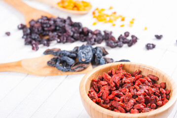 dried goji, cherry, raisin and plum fruits on white wood
