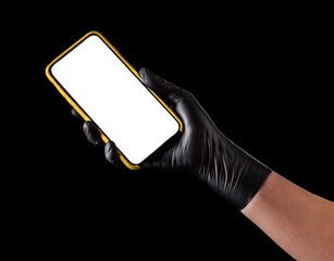 Hand in black glove holding mobile phone with blank screen isolated on black
