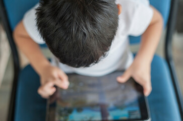 Penang, Malaysia - January 14, 2020 : Little kid's using digital touchscreen phone tablet computer...