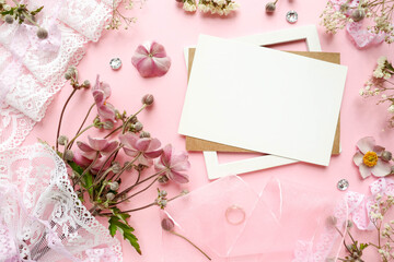 wedding card design. bouquet of flowers, wedding ring, white lace and envelope on a pink background