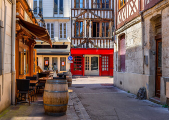 Fototapeta na wymiar Street with timber framing houses and tables of restaurant in Rouen, Normandy, FranceArchitecture and landmarks of Rouen. Cozy cityscape of Rouen