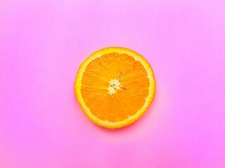 Slices of juicy orange on a bright pink background.