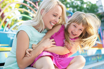 Loving young mother laughing embracing smiling cute funny kid girl 