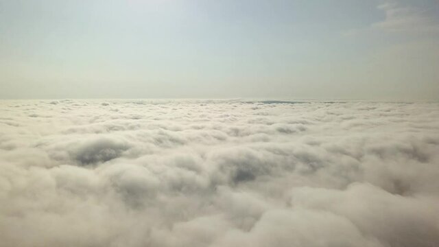 Aerial footage of flight over white puffy clouds.