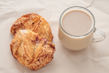 Cup of coffee and scones on brown crumpled paper background. Breakfast concept.