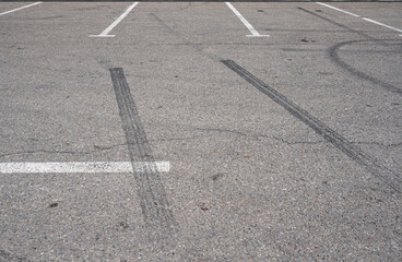 Asphalt texture with white line and tire marks.  Smooth asphalt road. Tarmac dark grey grainy road background.Top view