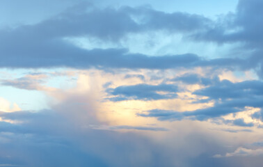 Fototapeta premium Dramatic cloudy blue sky background, sun behind the clouds.
