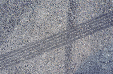 Naklejka premium Asphalt texture with white line and tire marks. Smooth asphalt road. Tarmac dark grey grainy road background.Top view