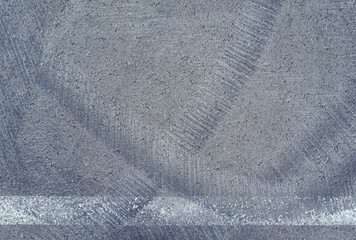 Asphalt texture with white line and tire marks.  Smooth asphalt road. Tarmac dark grey grainy road background.Top view