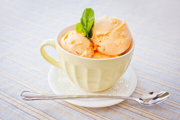 Cup of fruit ice cream with tablespoon near 