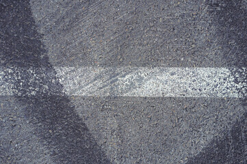 Fototapeta premium Asphalt texture with white line and tire marks. Smooth asphalt road. Tarmac dark grey grainy road background.Top view
