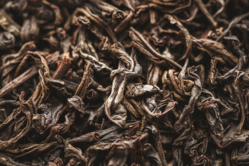 Black large-leaf tea as a background. Texture of dry black tea leaves.