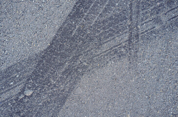 Naklejka premium Asphalt texture with white line and tire marks. Smooth asphalt road. Tarmac dark grey grainy road background.Top view