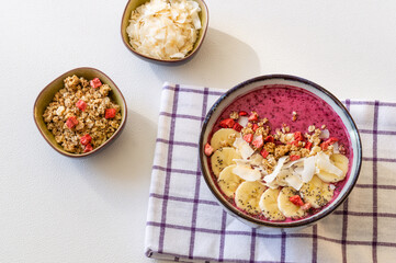 Smoothie bowl with chia seeds, musli, banana slices and coconut flakes.
