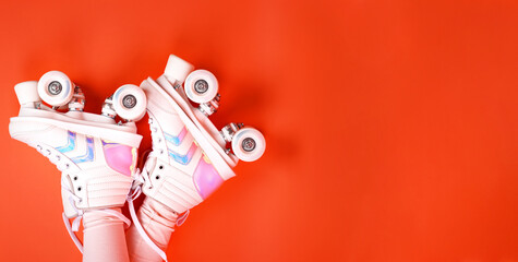 Roller skates on the legs of a urenburg. Retro rollers on a bright background. The concept of...