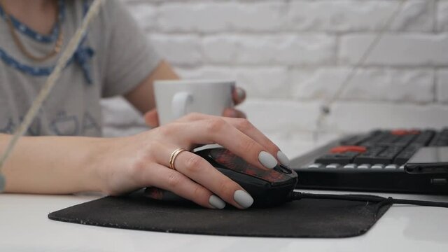 The woman's hand is working with the mouse on the table and.Remote work, freelancer, workplace